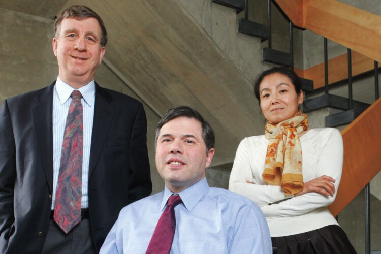 Three people, including a man in a wheelchair, pose