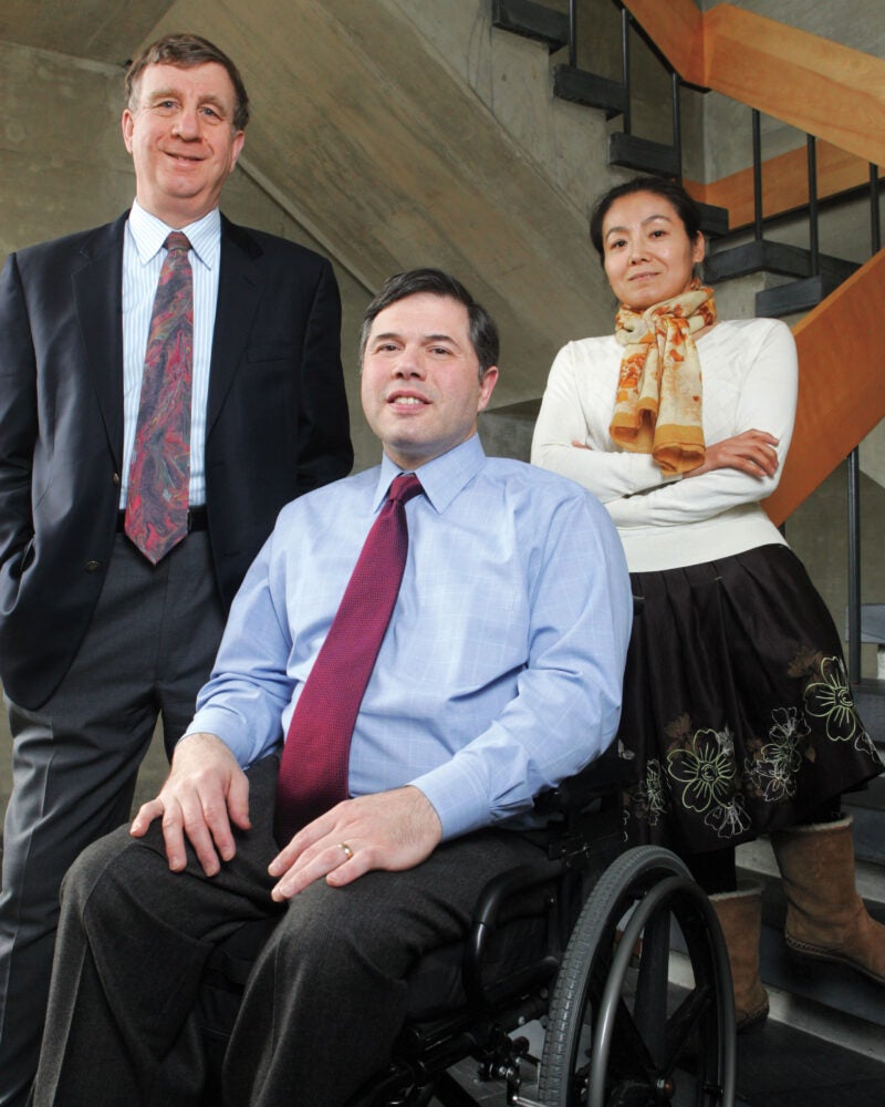 Three people, including a man in a wheelchair, pose