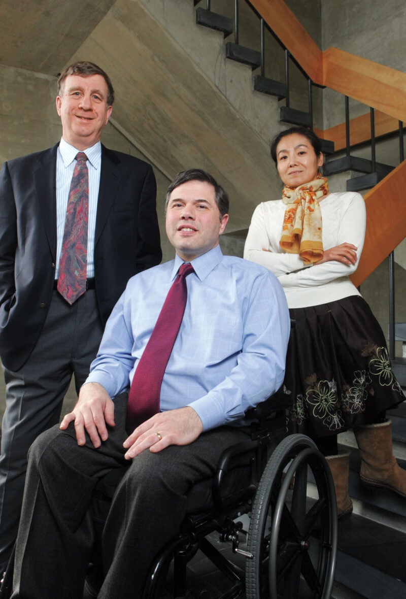 Three people, including a man in a wheelchair, pose