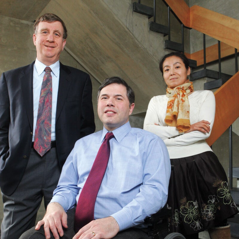 Three people, including a man in a wheelchair, pose