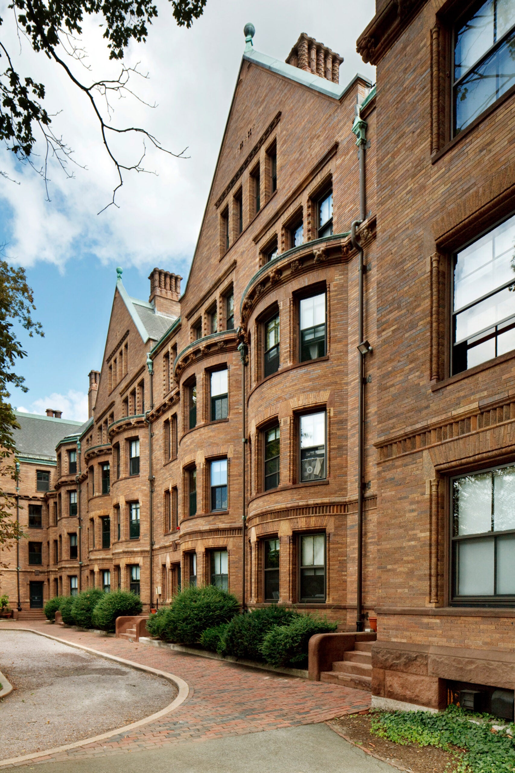 A side view of a red brick building and driveway.