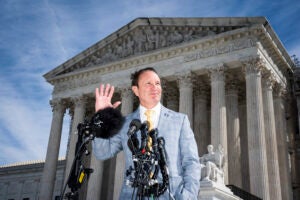 Jeff Landry speaking into microphones in front of the Supreme Court