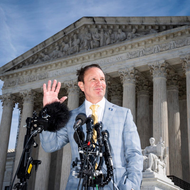 Jeff Landry speaking into microphones in front of the Supreme Court