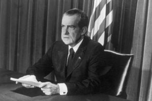 Richard Nixon seated at a desk.