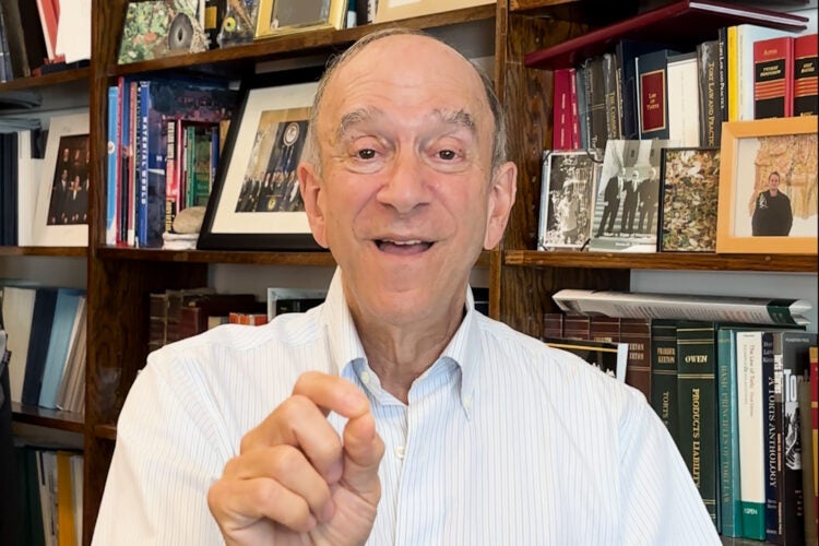 Richard Lazarus speaks in front of a bookcase.