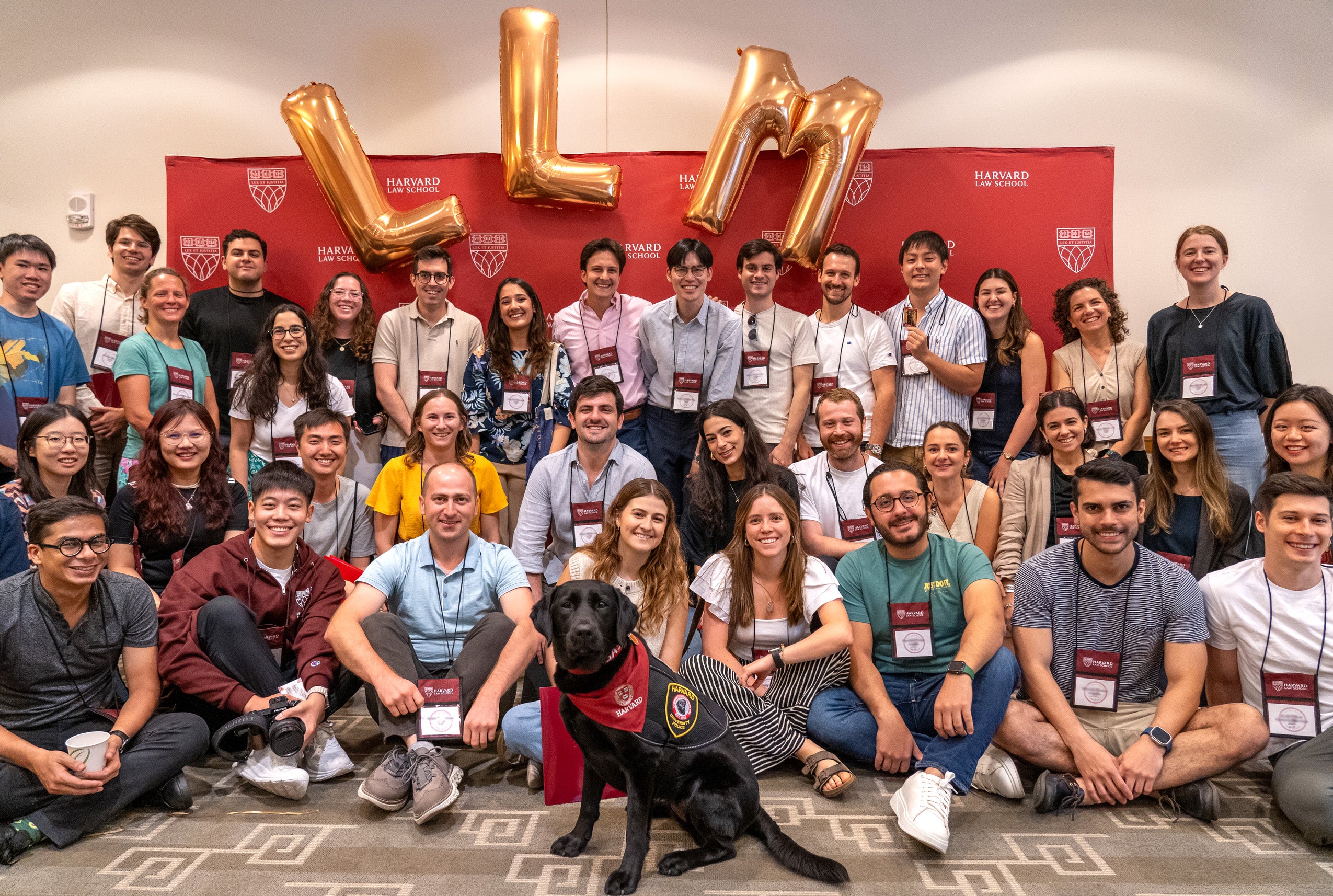 Students pose with Sasha, the Harvard Community Engagement Dog, during an LLM orientation session