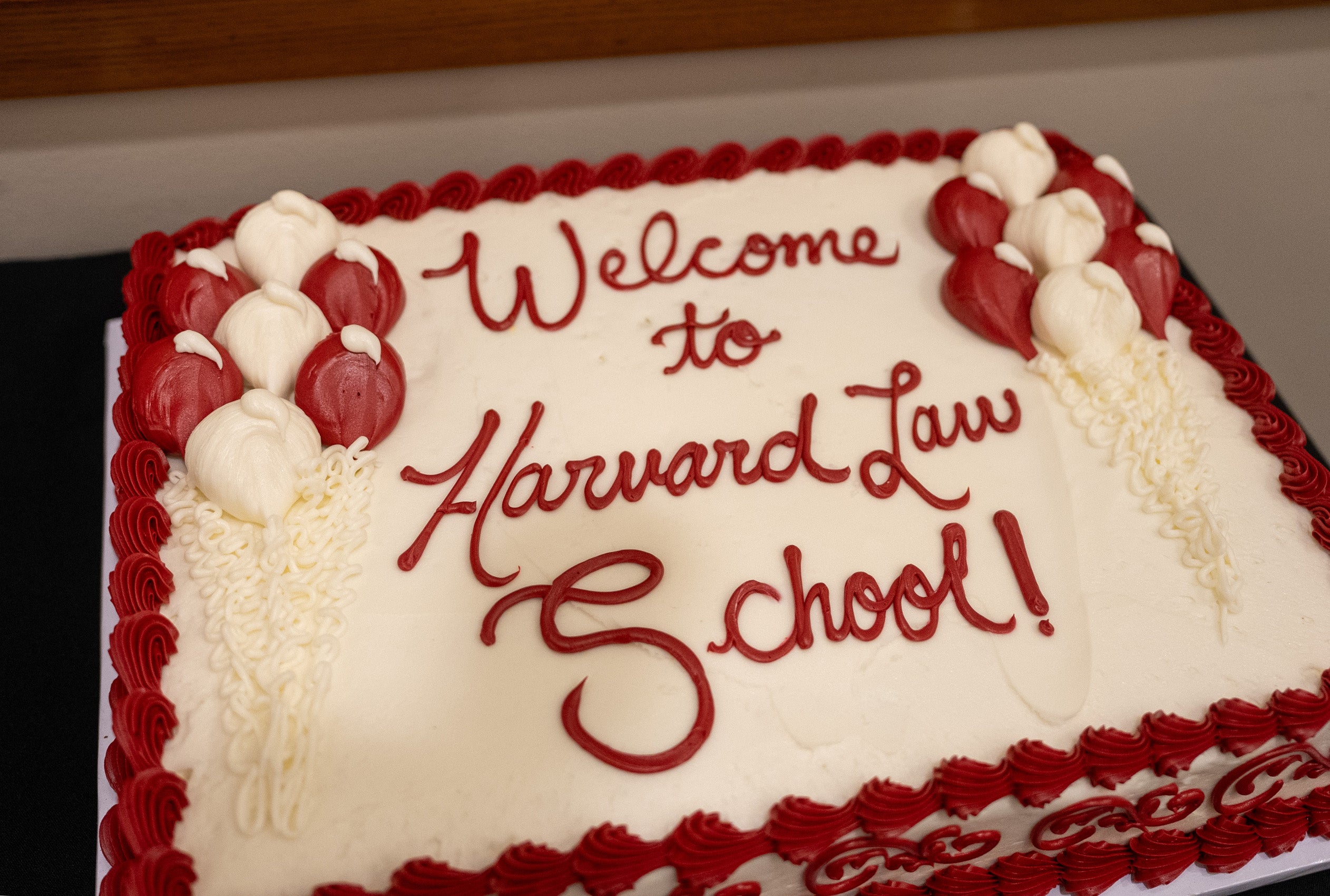 A cake decorated in red and white frosting with the words welcome to Harvard Law School