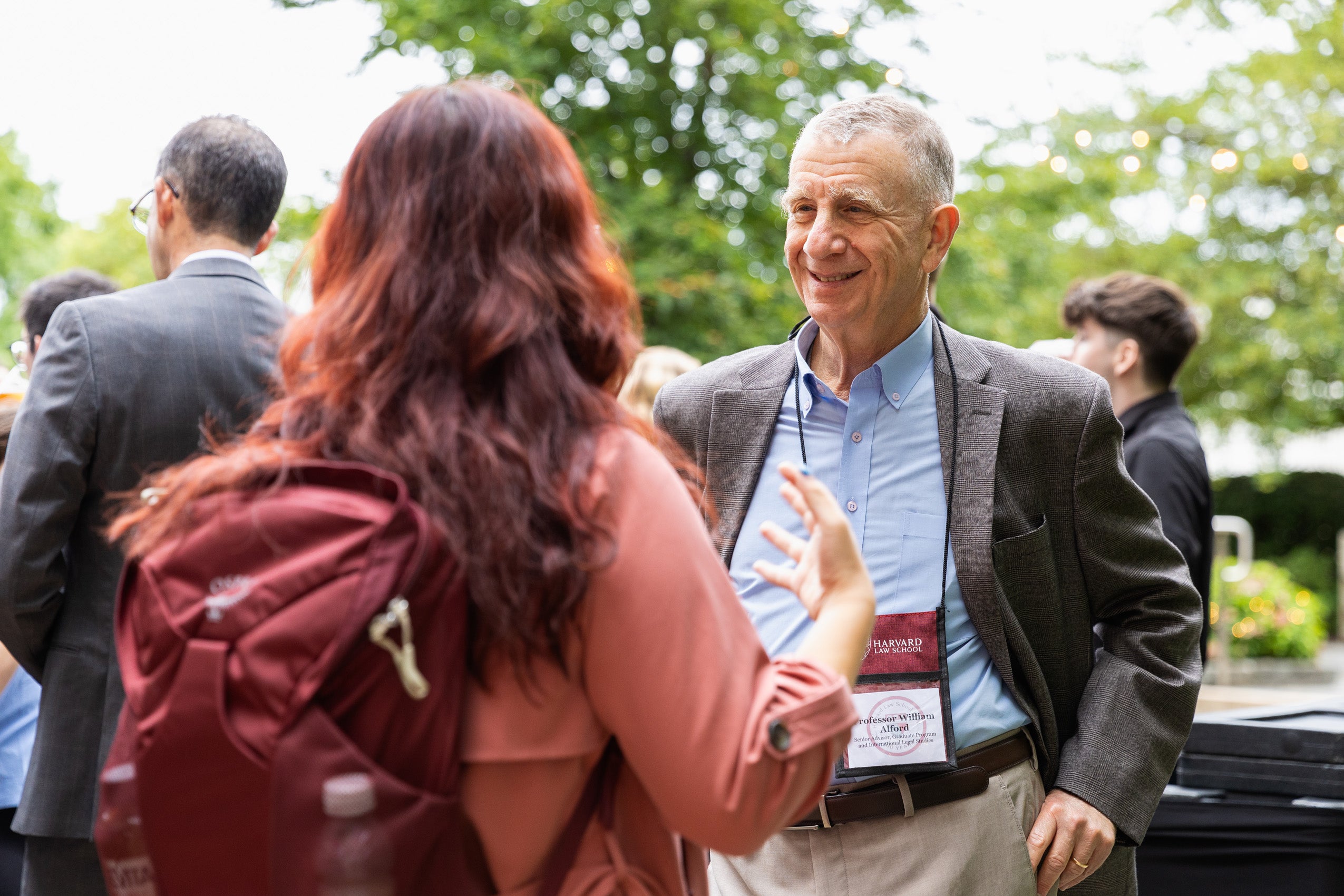 A professor speaks with a student at an orientation event.