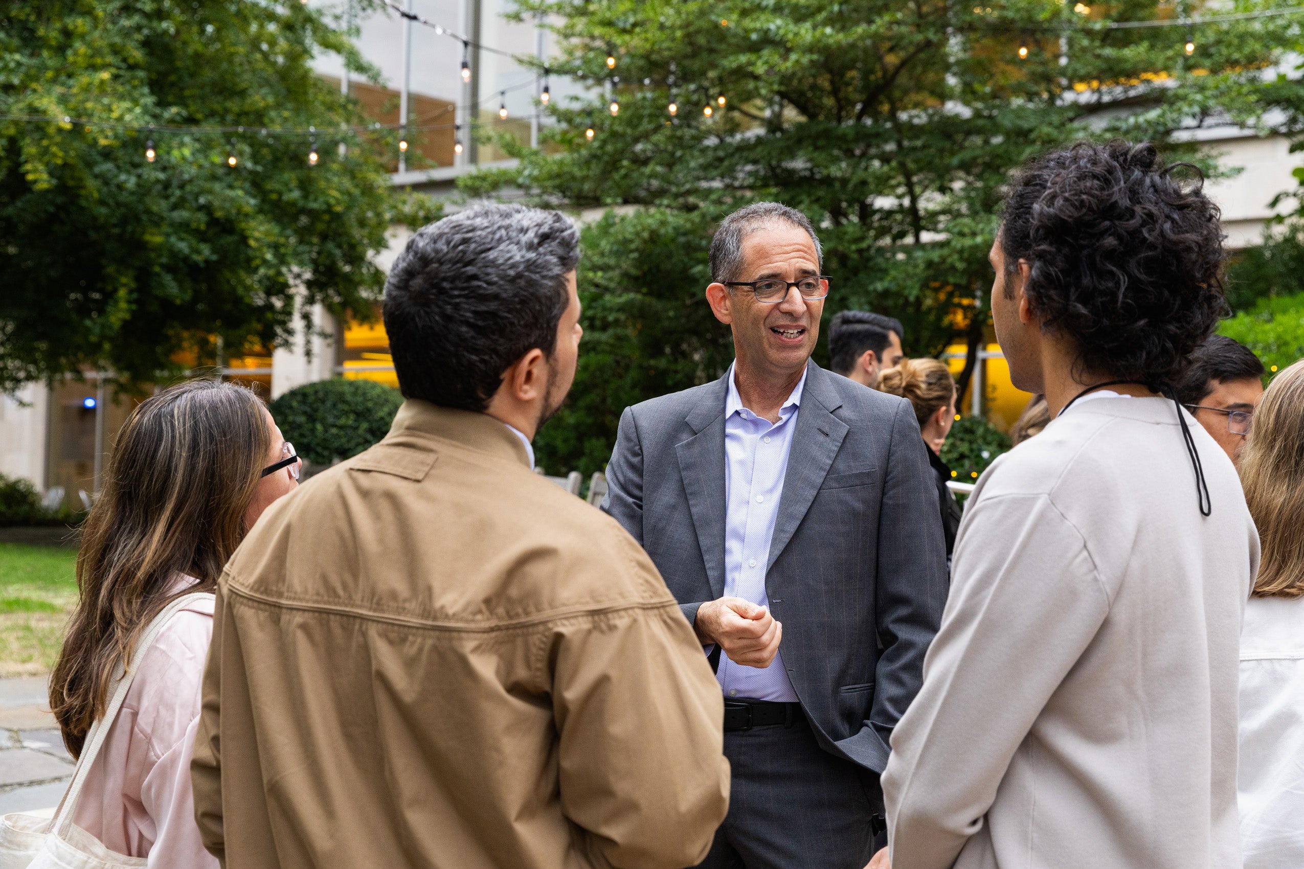 Dean Goldberg chatting with students outside at a reception