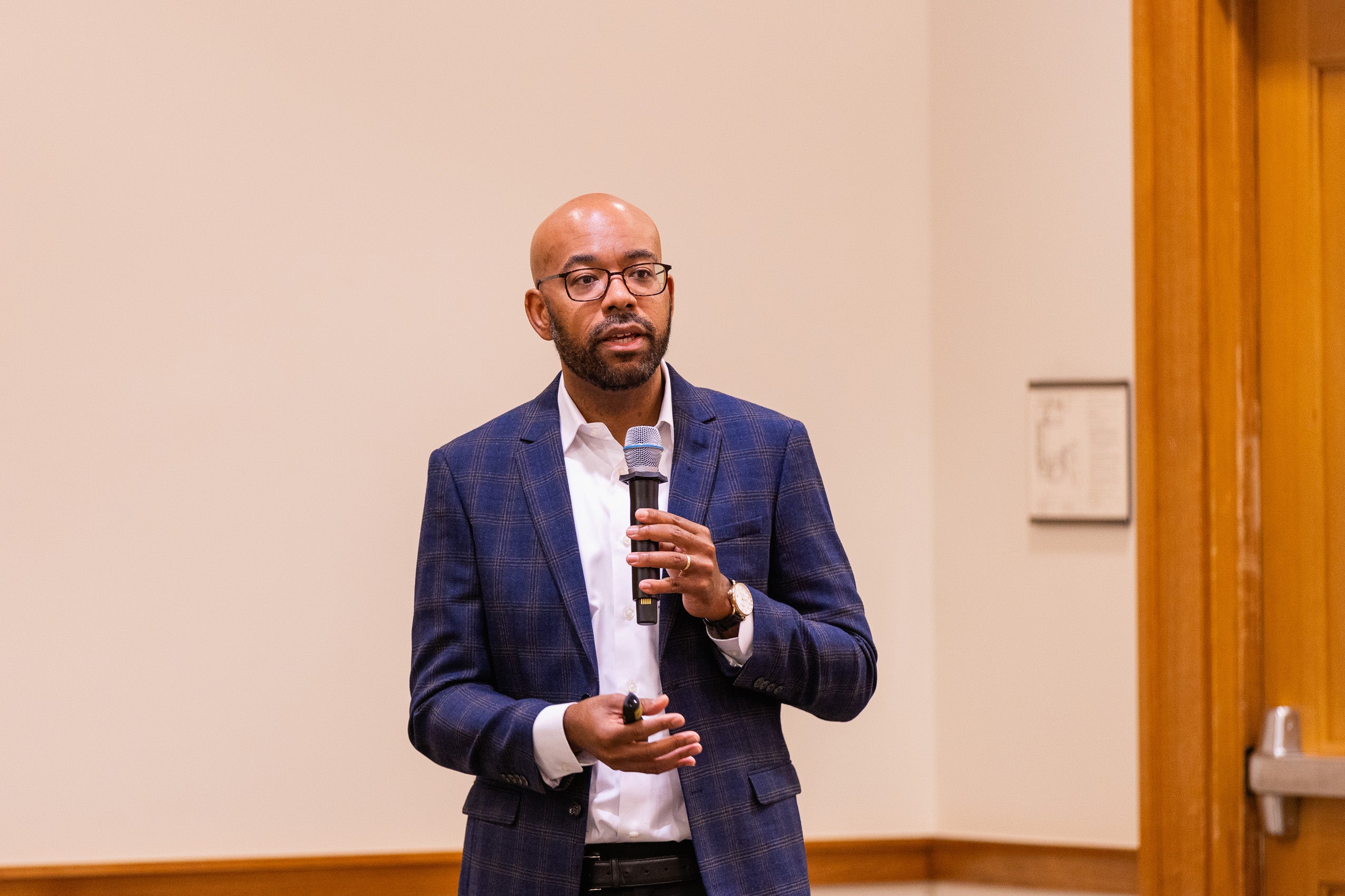 A man with a microphone speaks at an event.