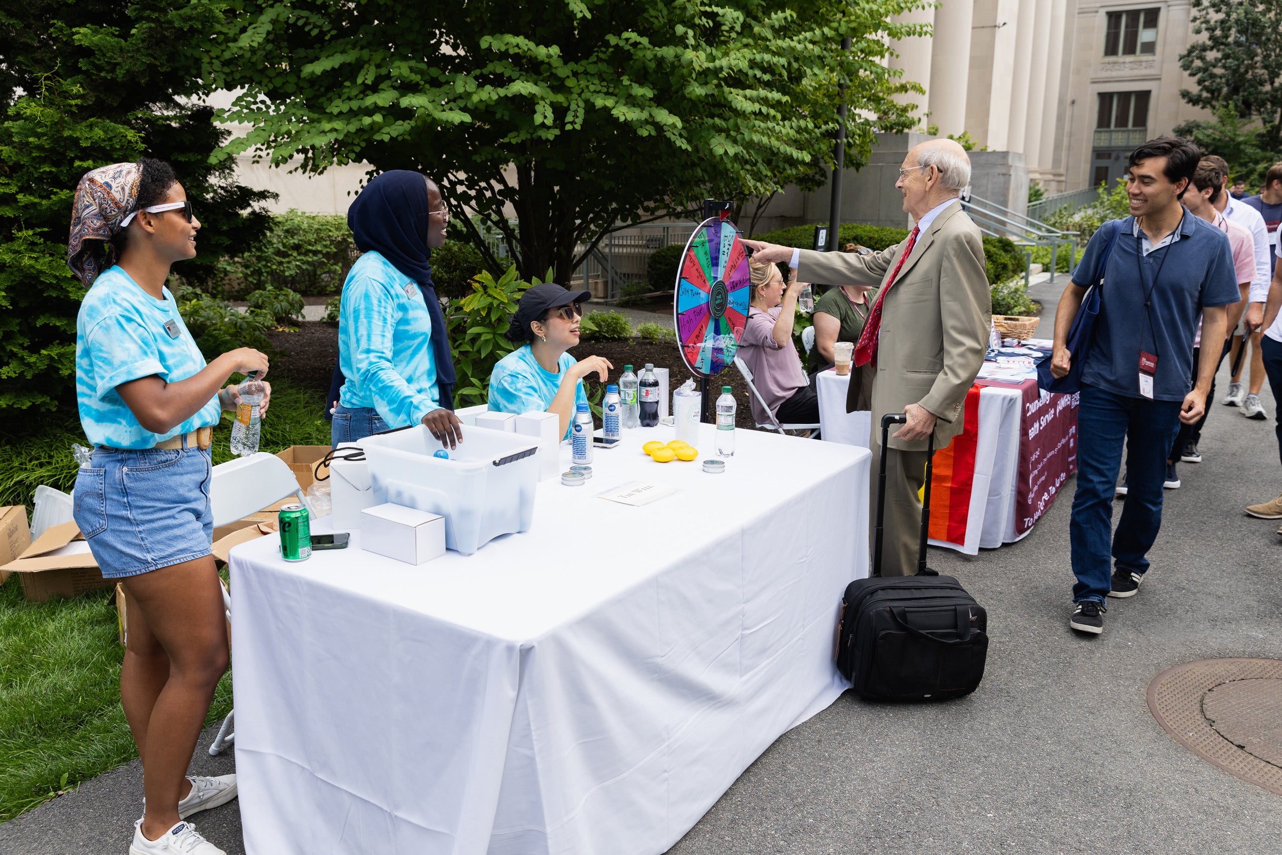 A man points to a wheel at a table during orientation.