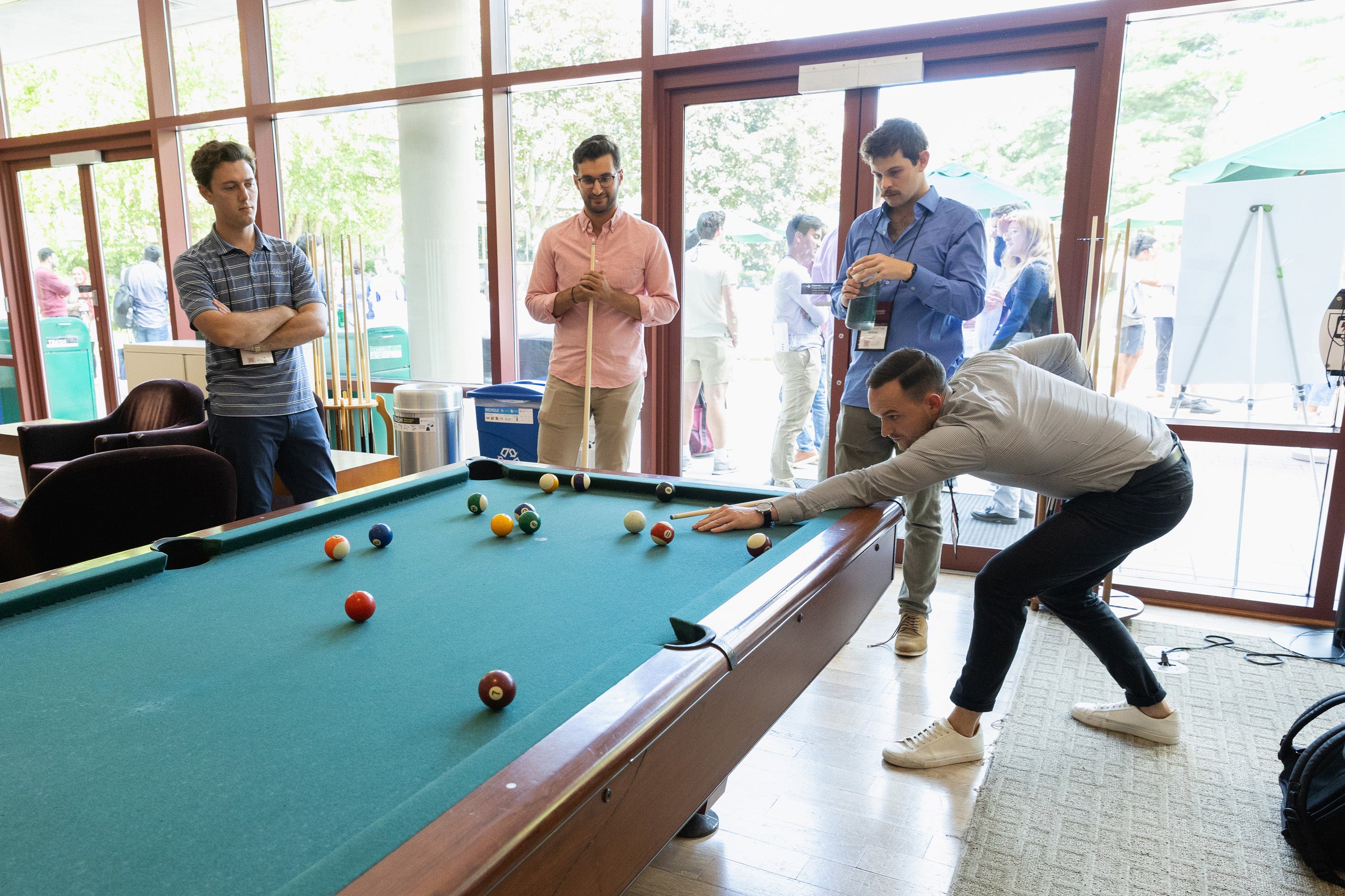 Students play a game of pool.