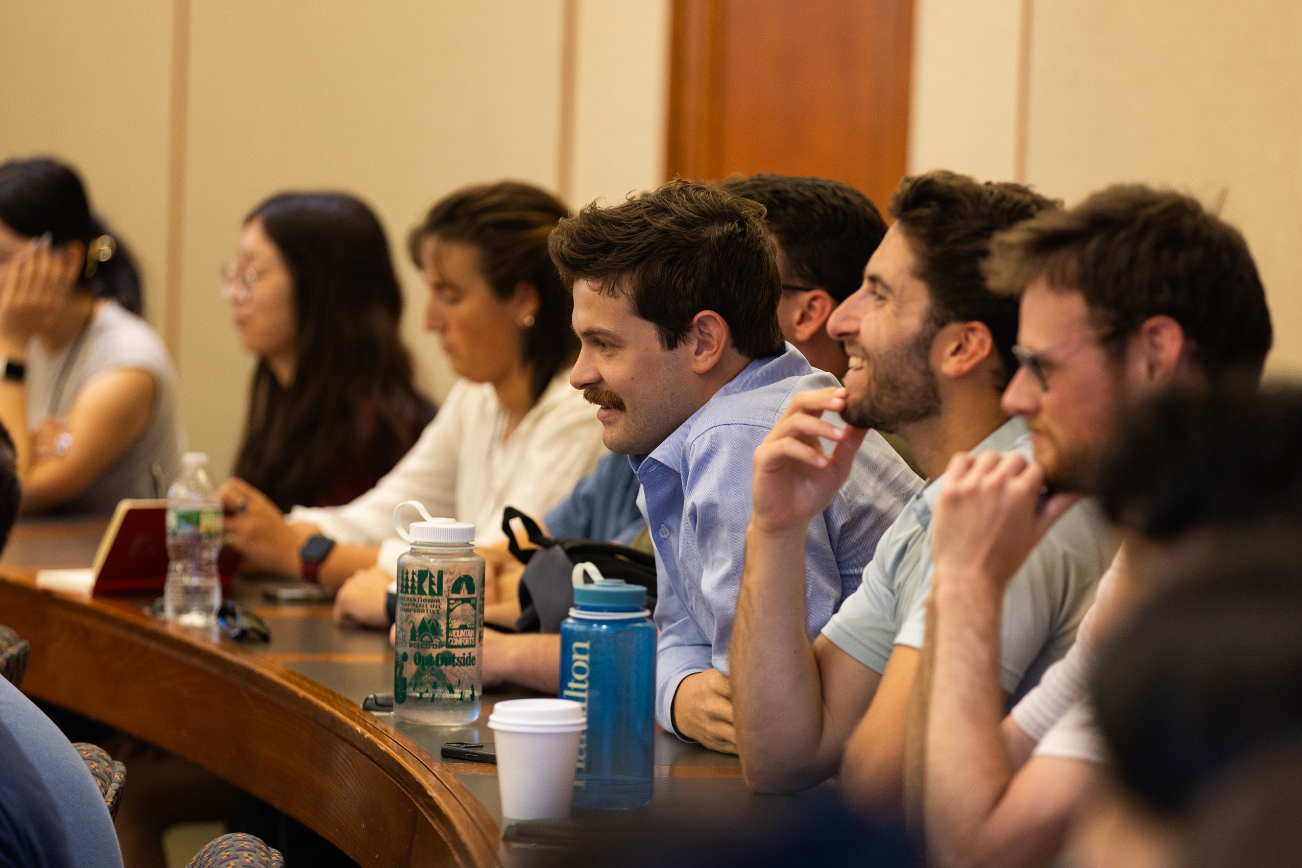 A row of students listen in a classroom.