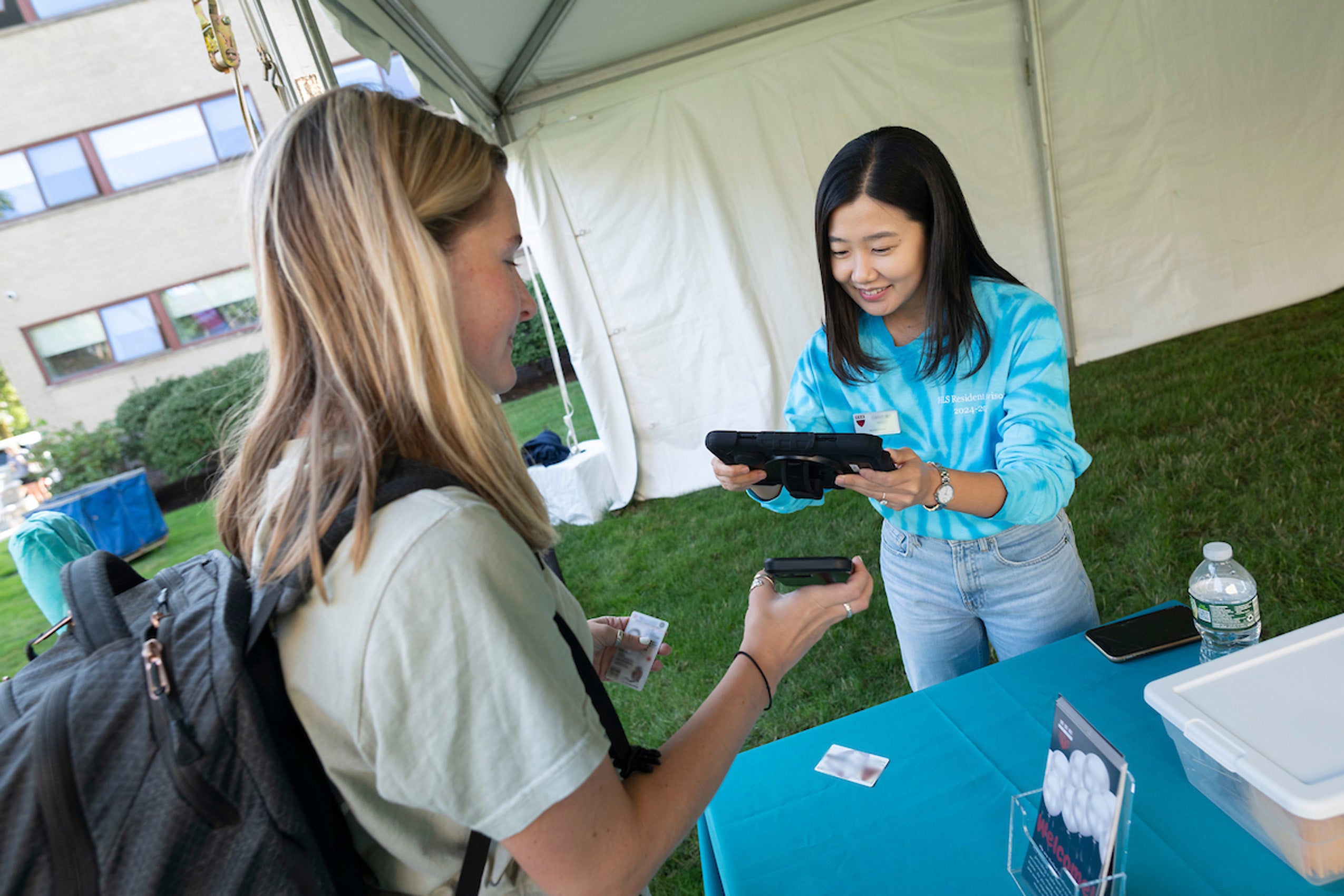 A women checks a student in as part of move in day.