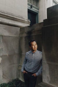 A portrait of a man near a gray granite building