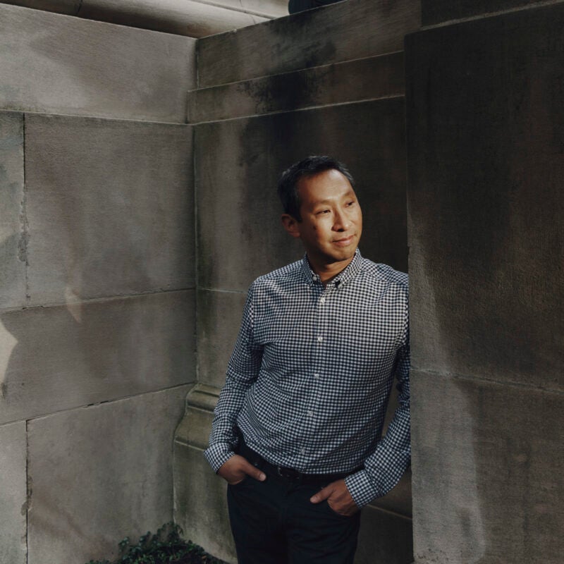 A portrait of a man near a gray granite building