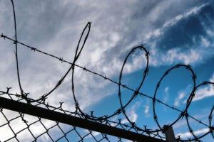 Barbed wire on top of chainlink fence.