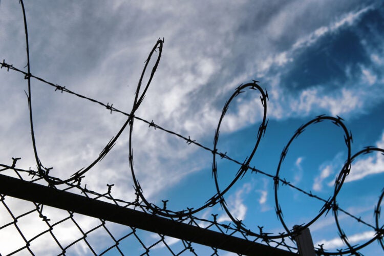 Barbed wire on top of chainlink fence.