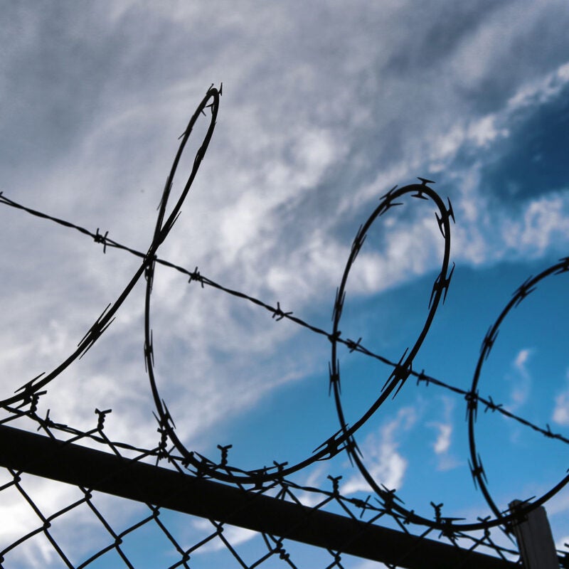 Barbed wire on top of chainlink fence.