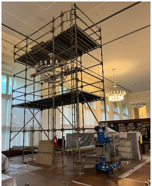 Scaffolding surrounding a large chandelier.