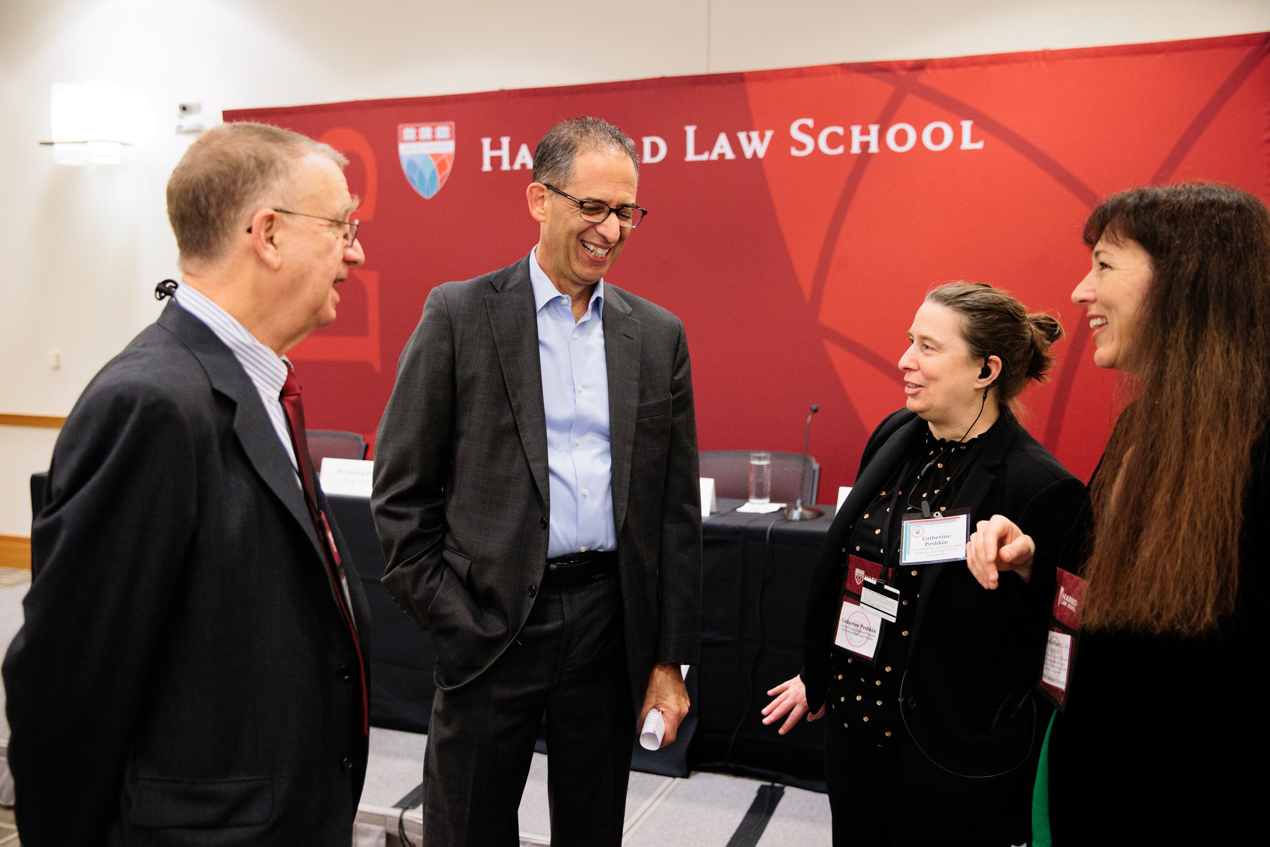 Four individuals sharing a light moment before an event.