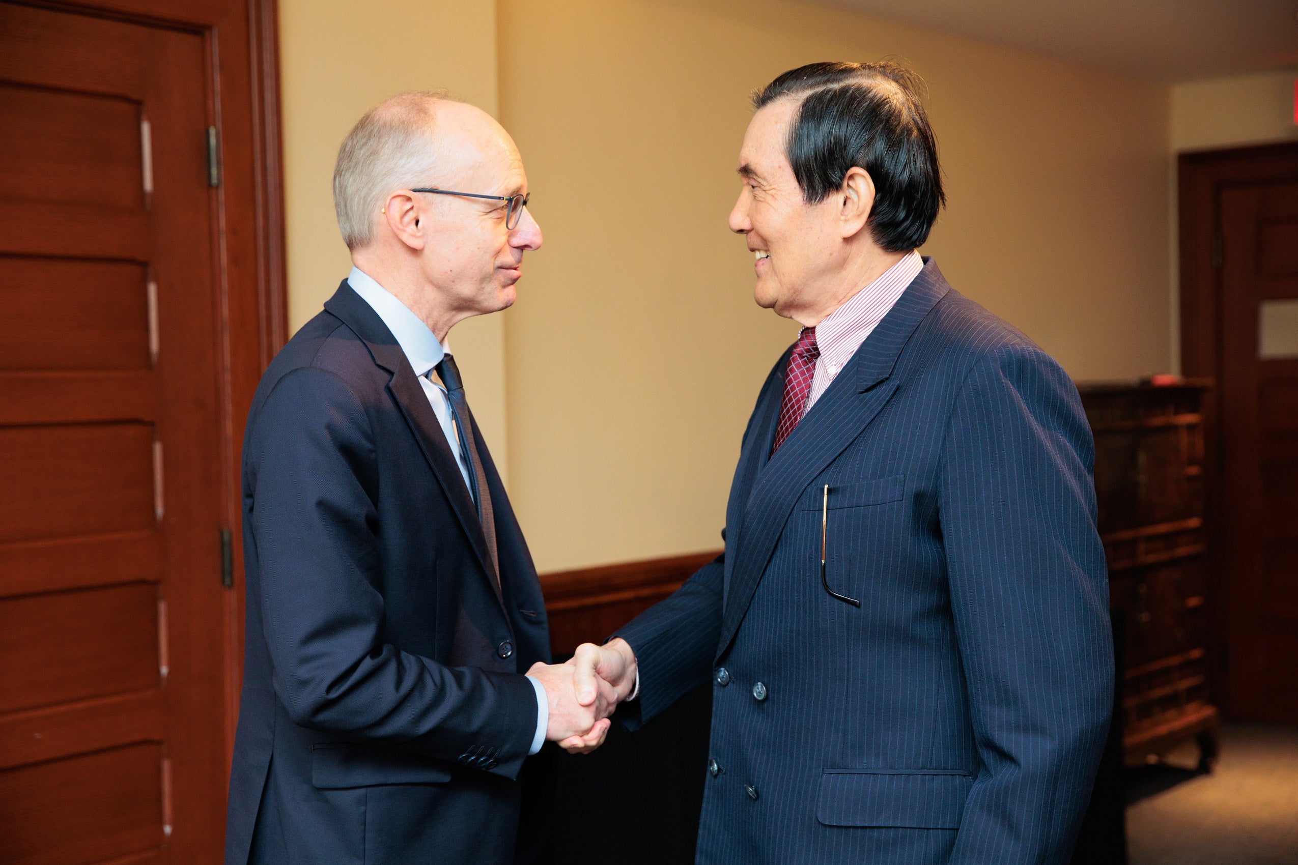 Two men shake hands in a room