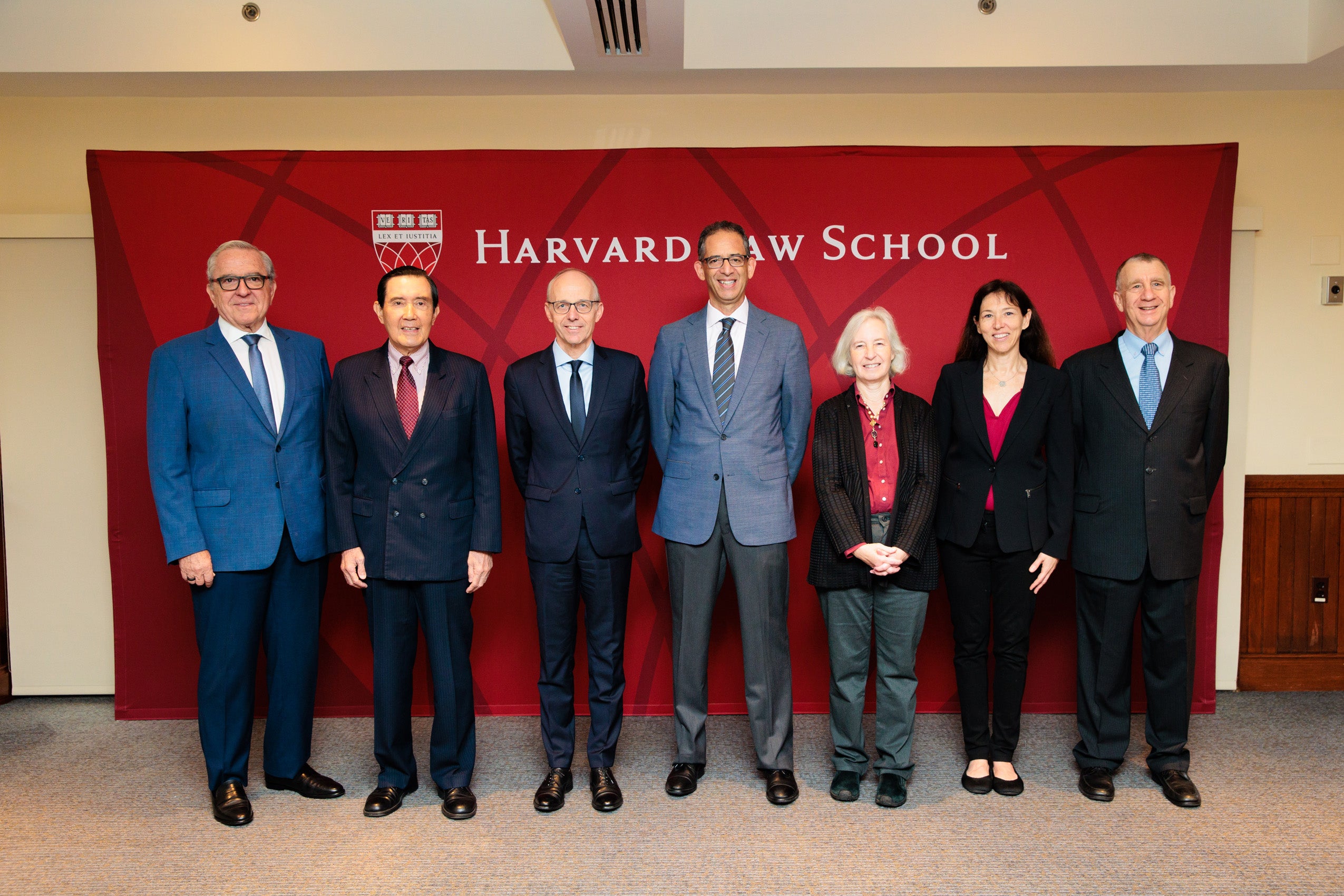 A posed photo fo seven people in front of a backdrop