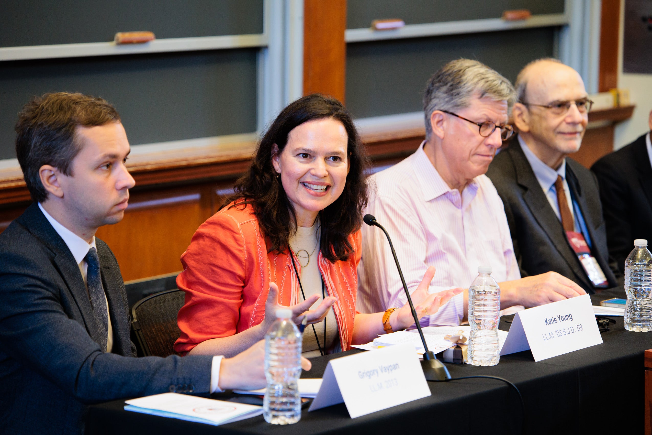 A close of of four panelists sitting at a table at a talk