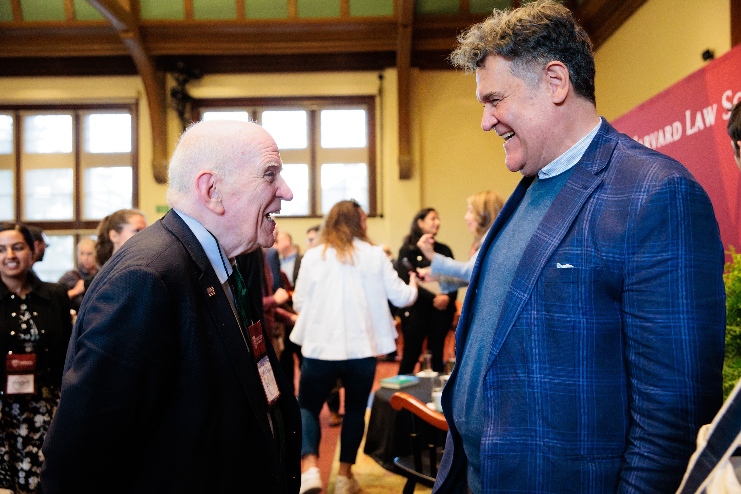Two men greet each other happily before an event.