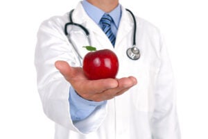 Doctor holding a red apple.