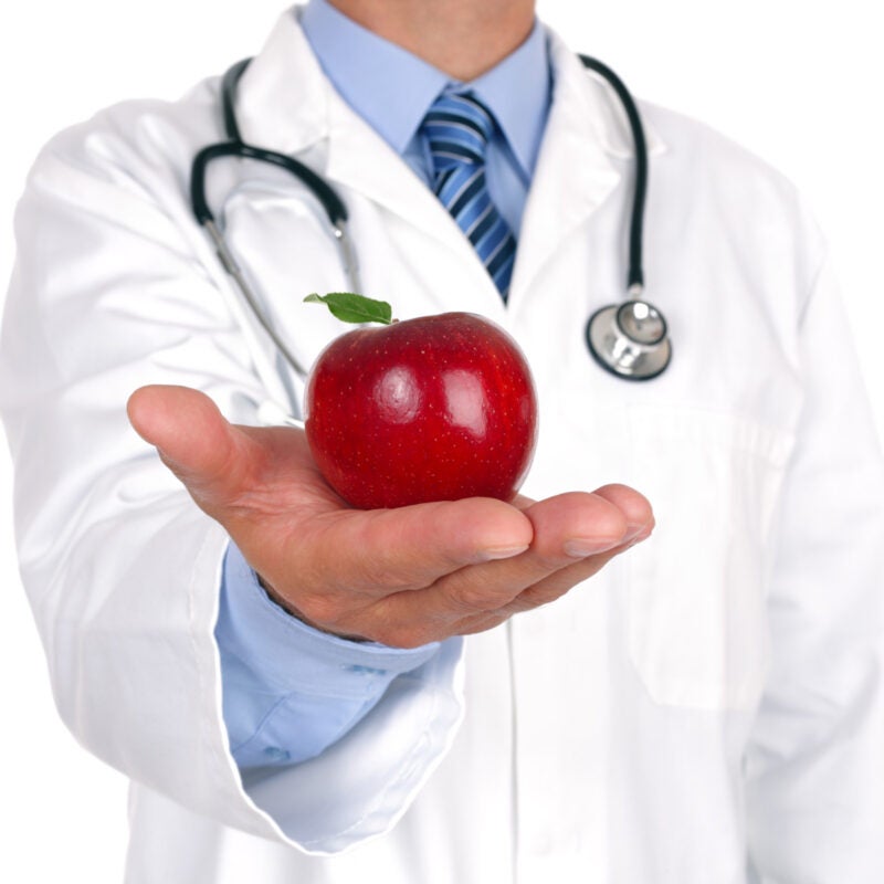 Doctor holding a red apple.