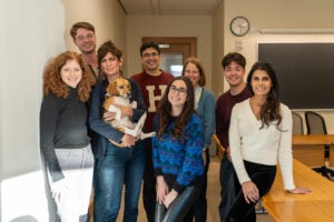 a group of students and instructors pose with a beagle