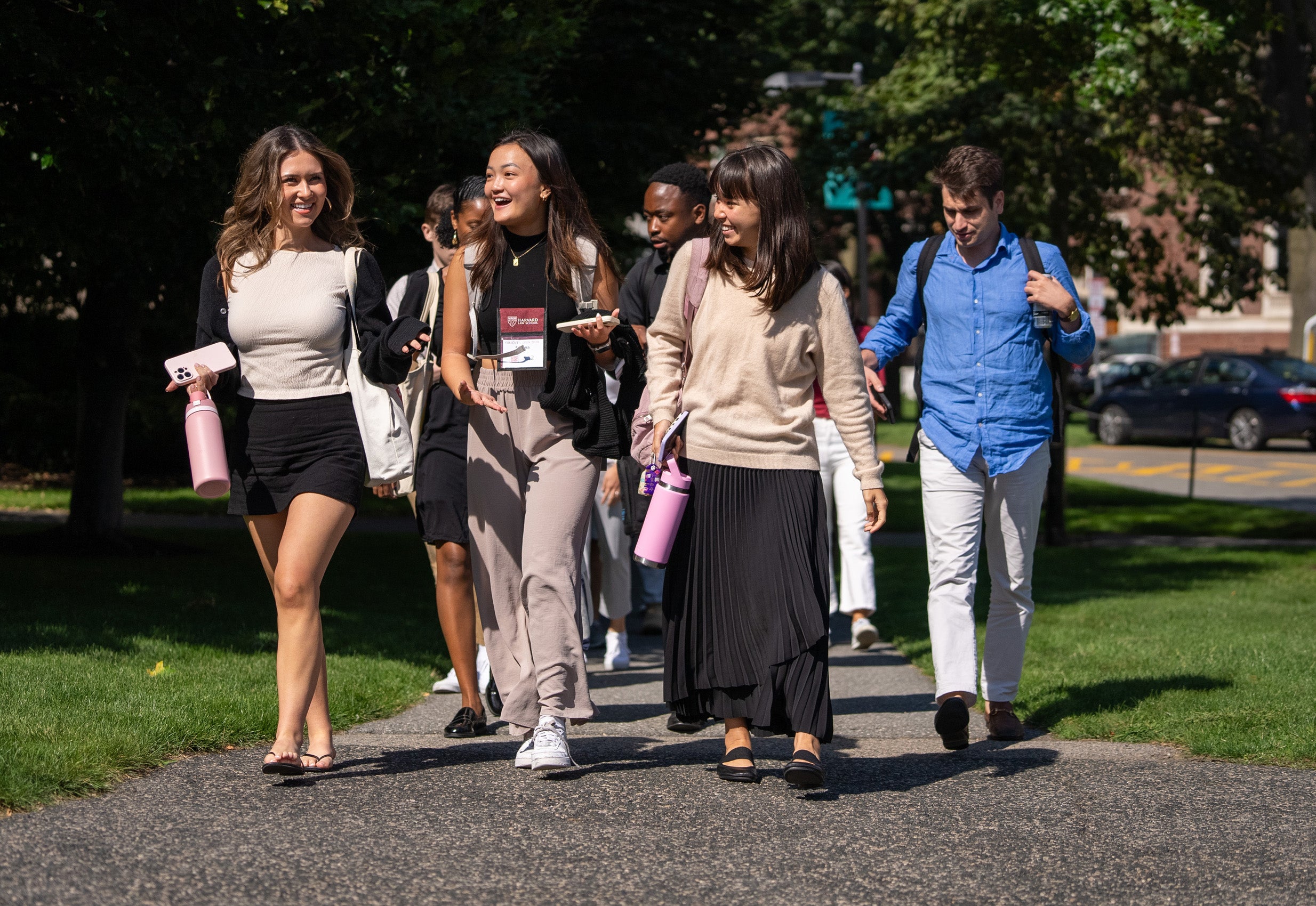 Several students walk along a campus pathway.