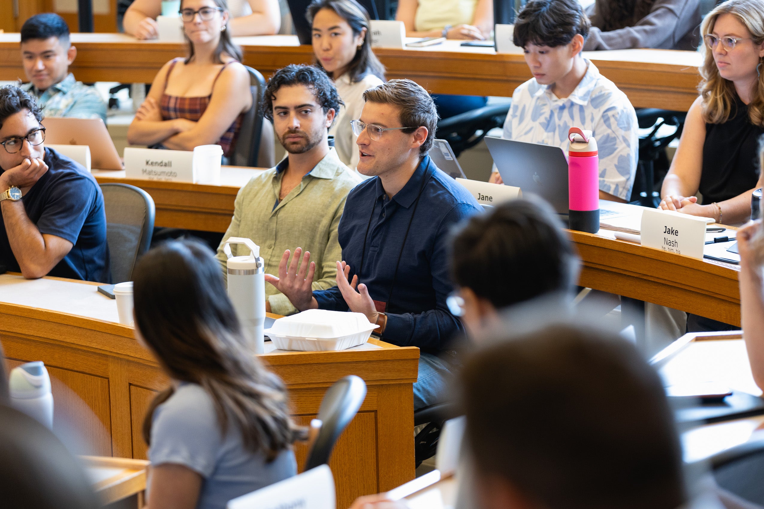 A man sitting in a class makes a point.
