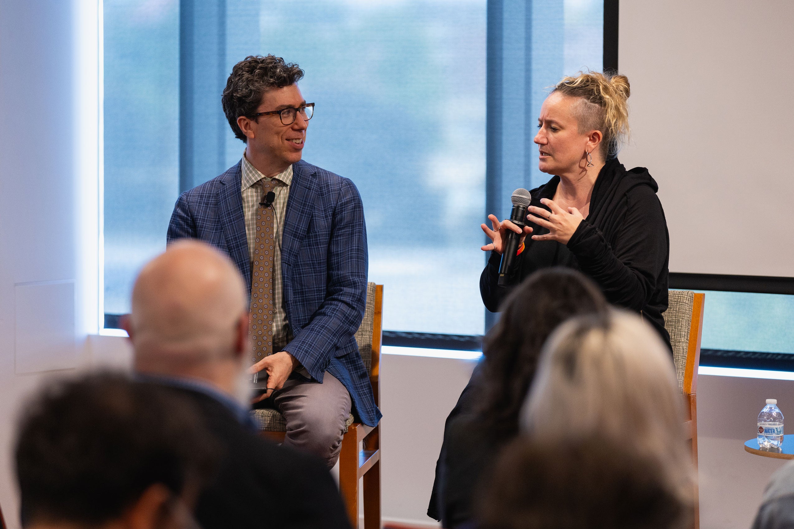 Two people speaking at the front of a room