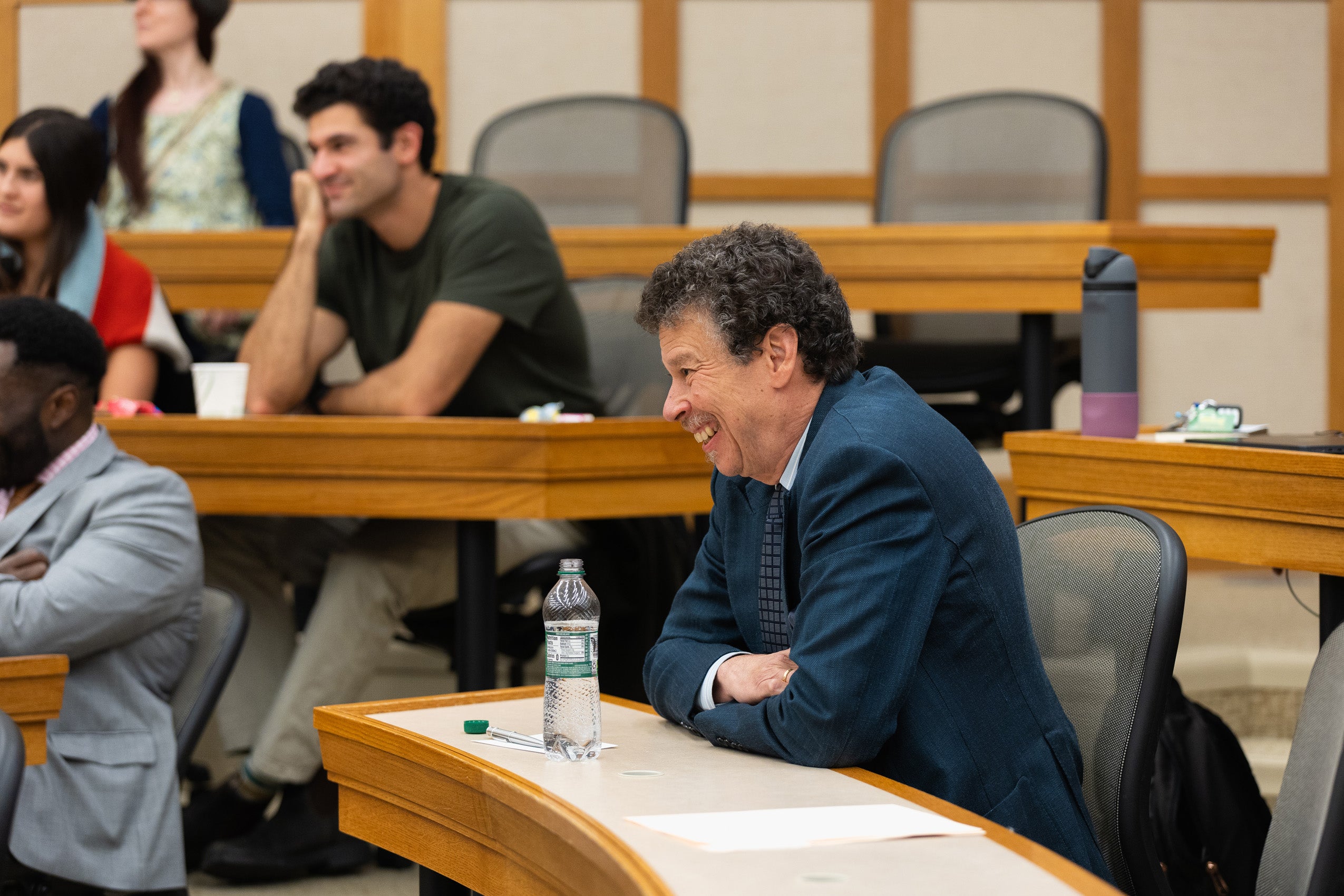 Professor David Wilkins sits in a classroom listening to a talk.