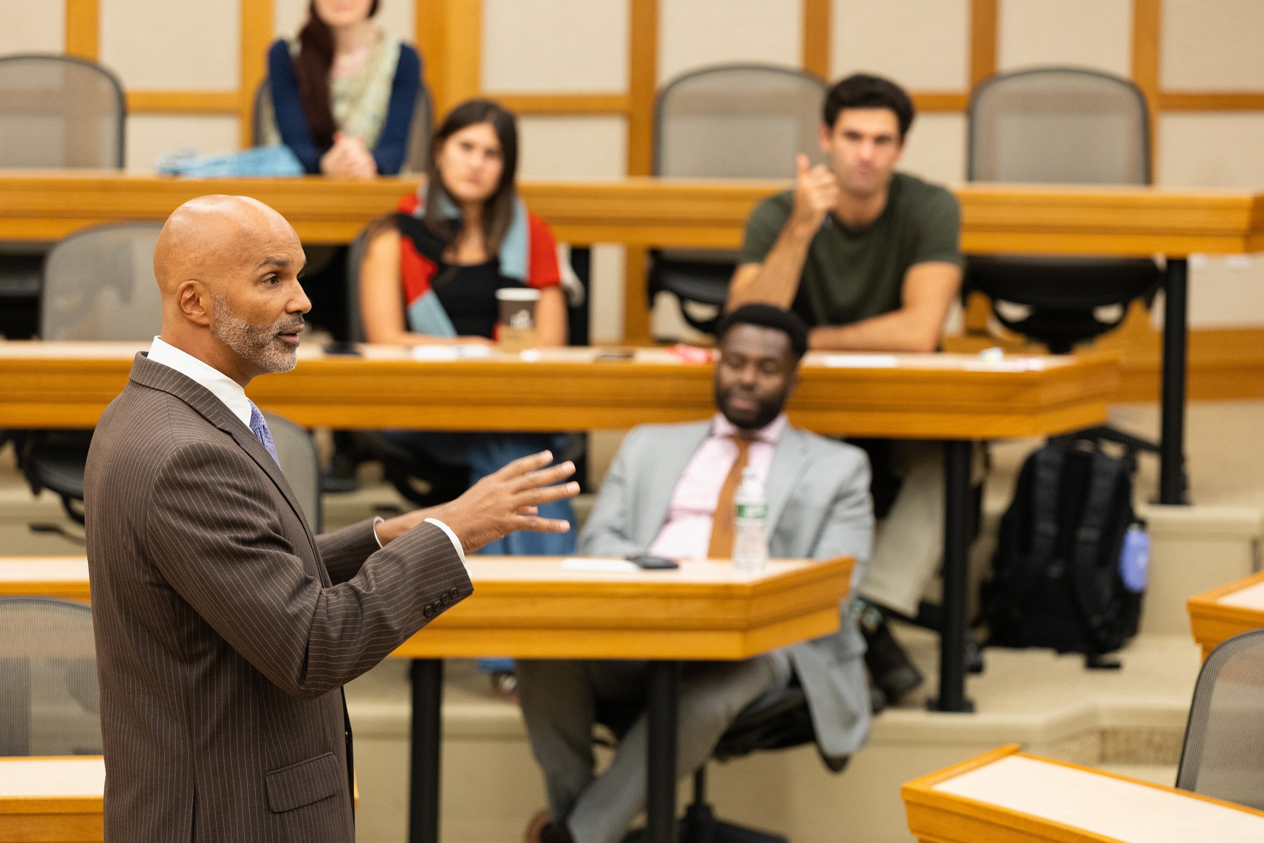 A man speaking in front of a classroom of students.
