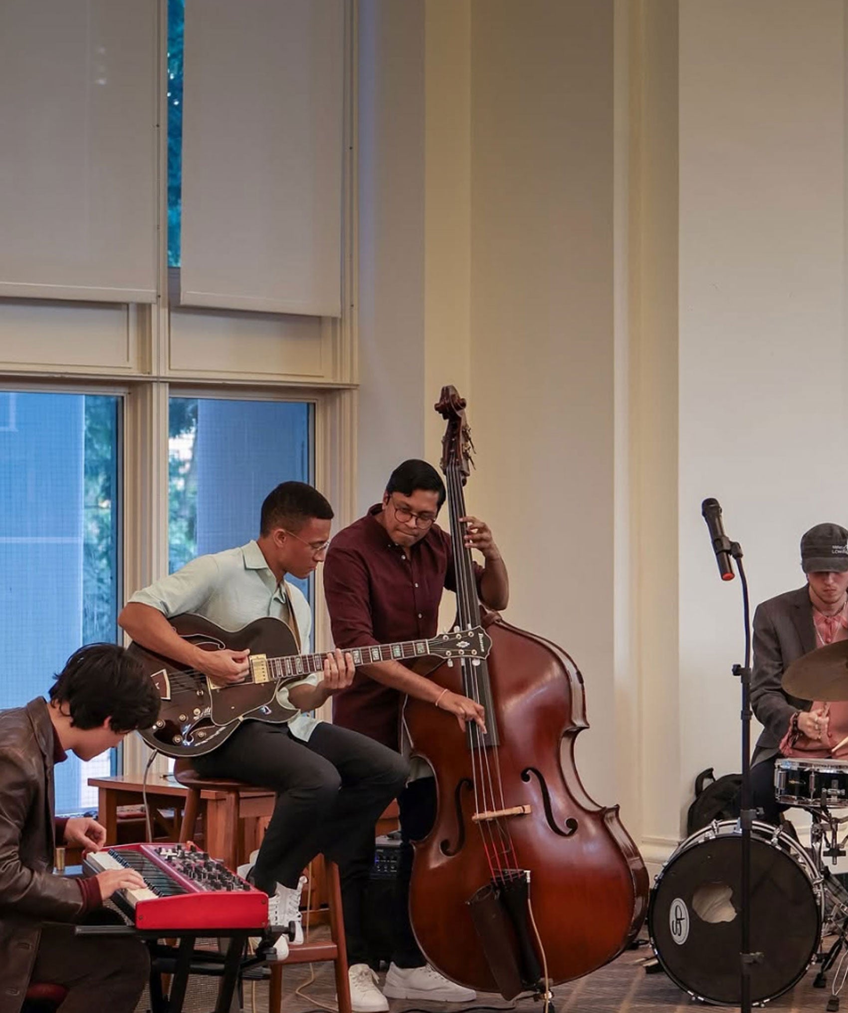 Musicians playing keyboard, base, guitar and drums.