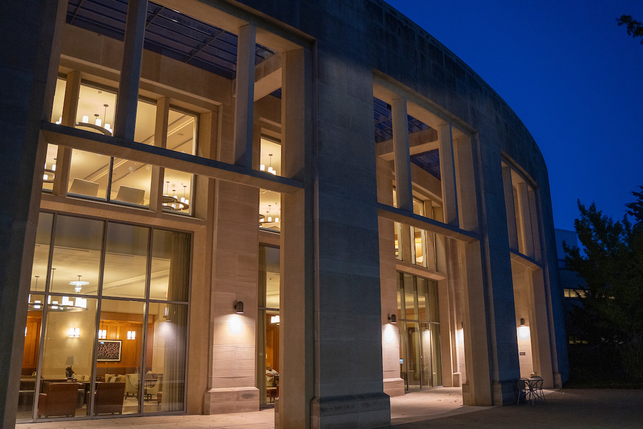 An early evening shot of a a building glowing with inner lights.