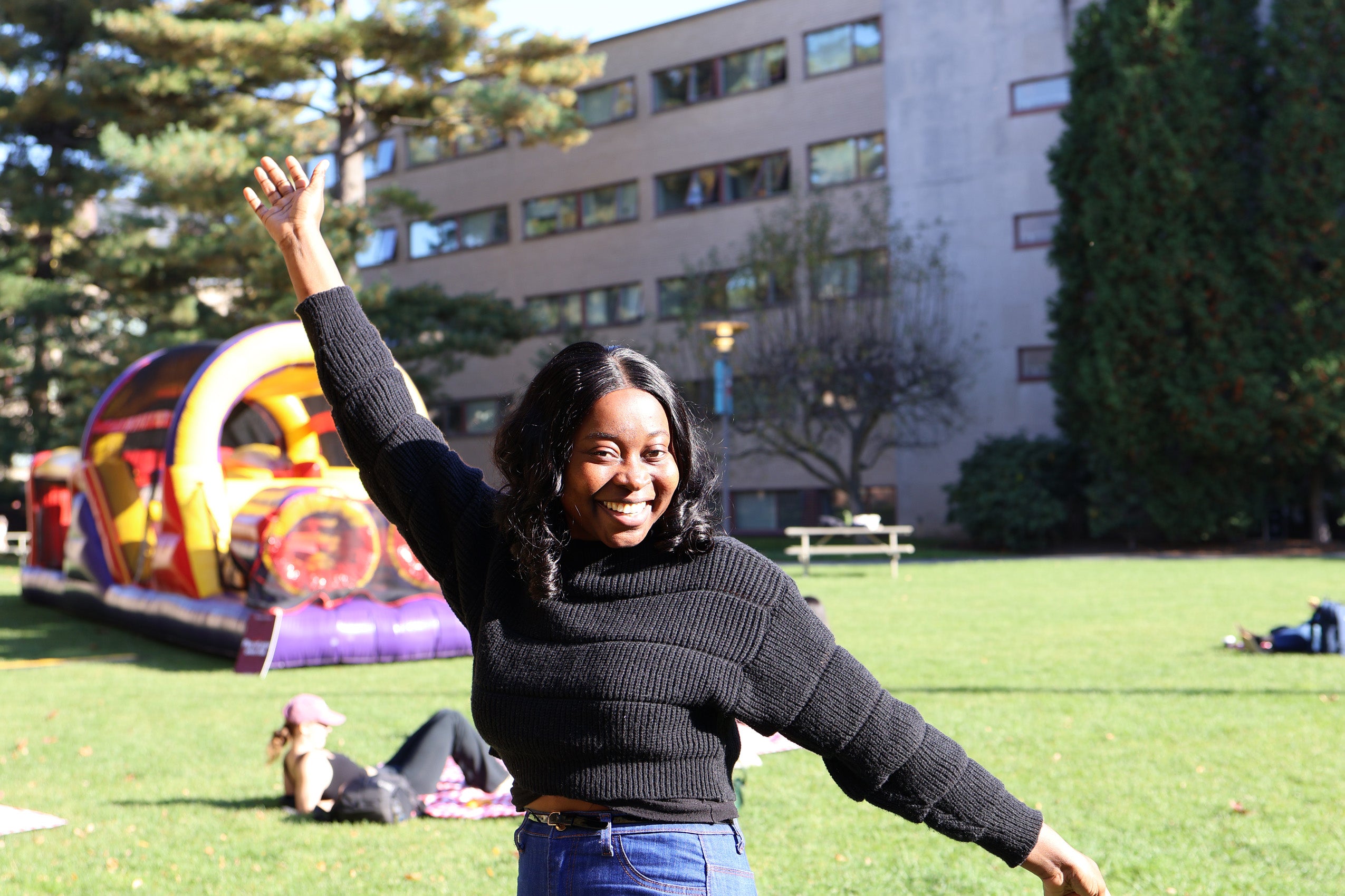 A student strikes a fun pose on campus at an outside fall festival.