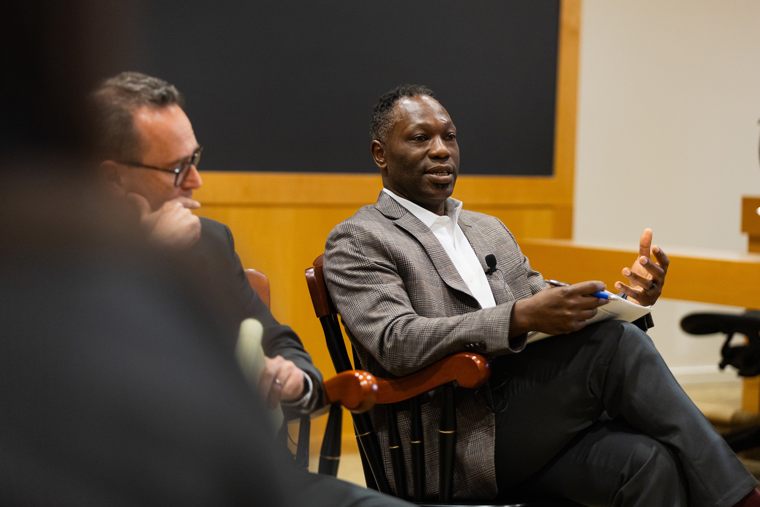A professor makes a point on a panel at an event.