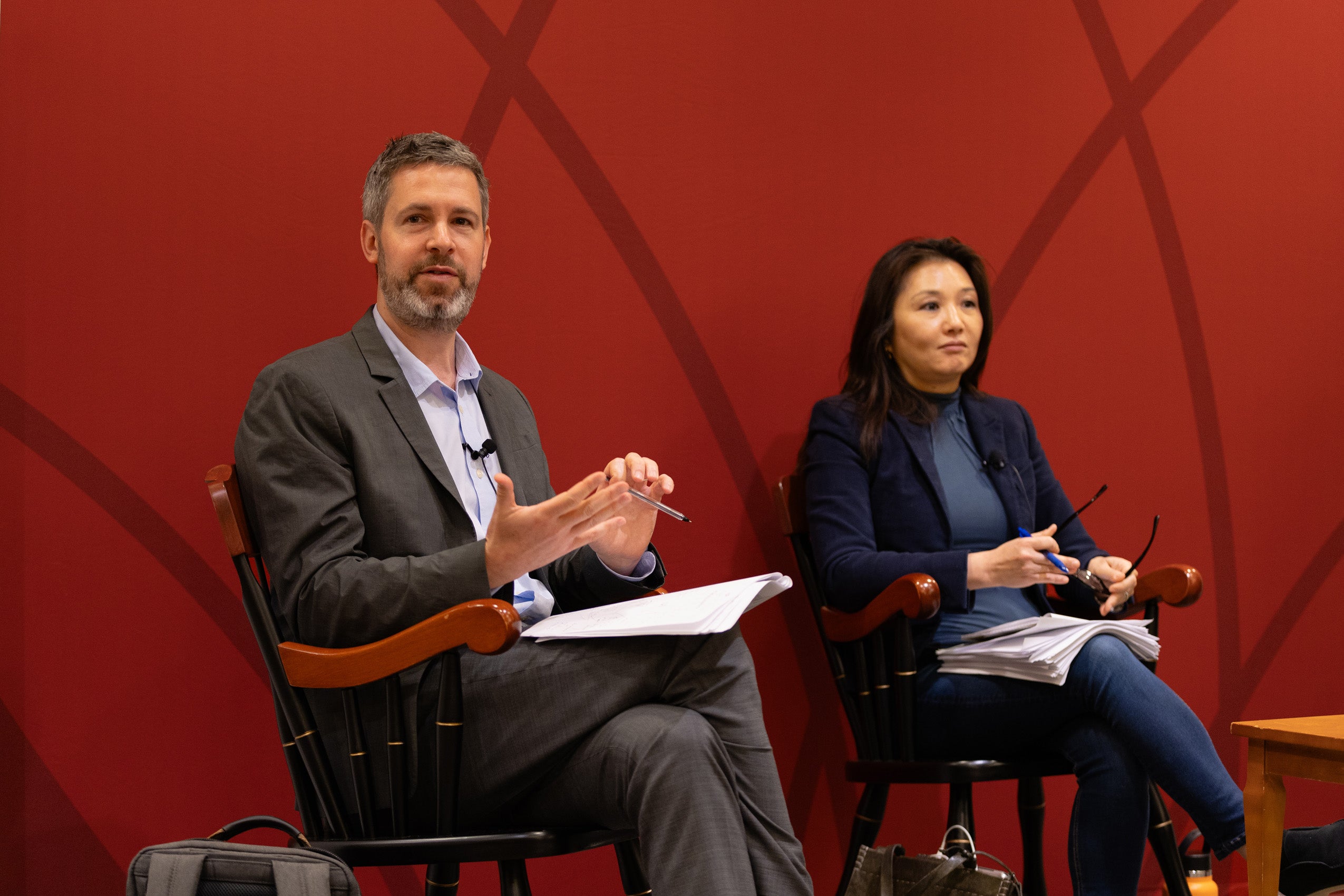 A panelist and professor discuss a topic at an event.