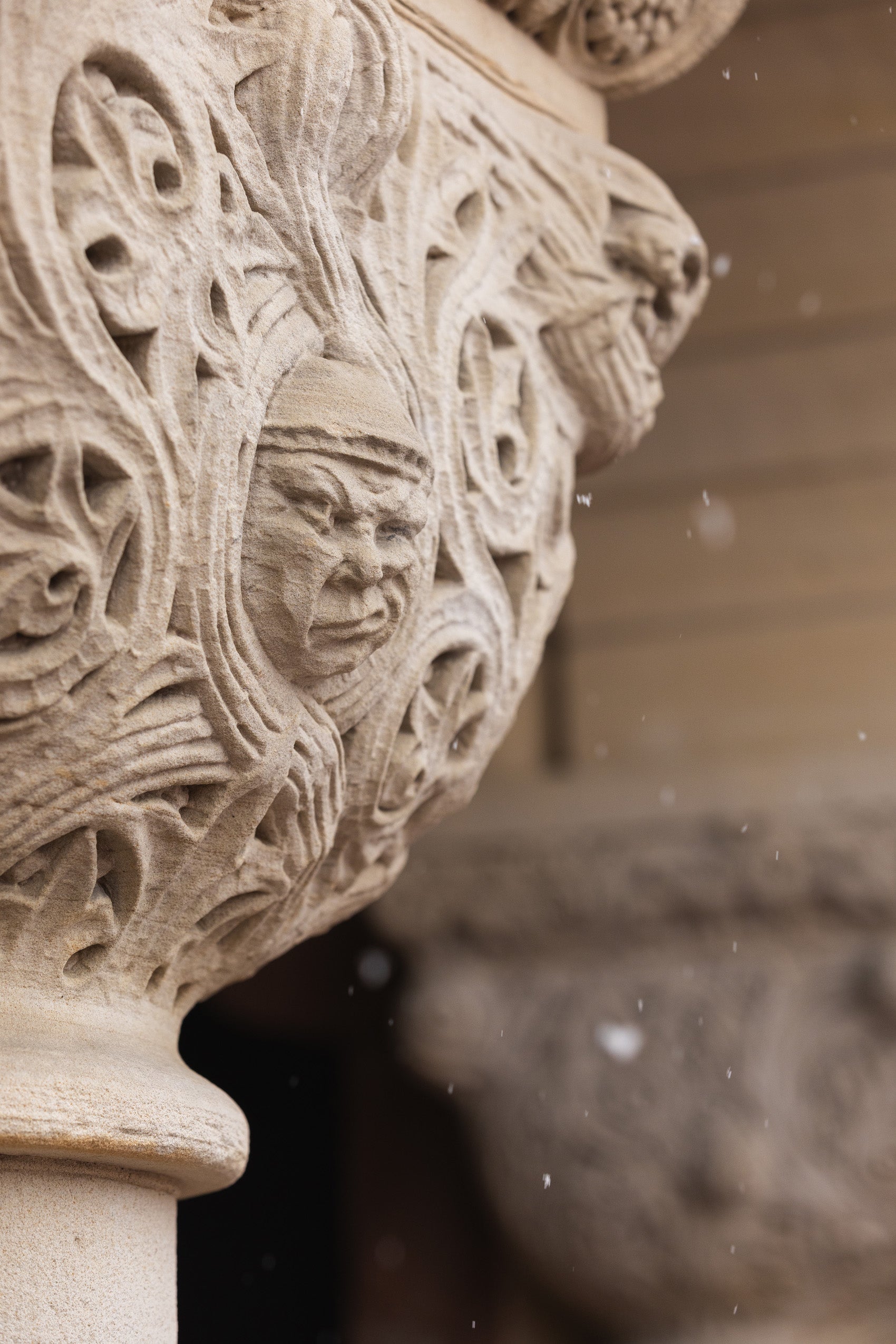 A detail of a carved face figure expressing being