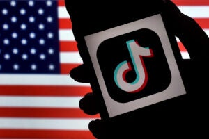 TikTok logo on American flag background.