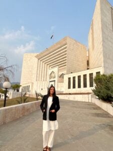 a woman stands in front of the Supreme Court of Pakistan