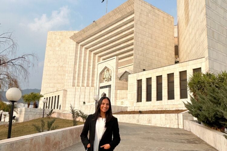 a woman stands in front of the Supreme Court of Pakistan
