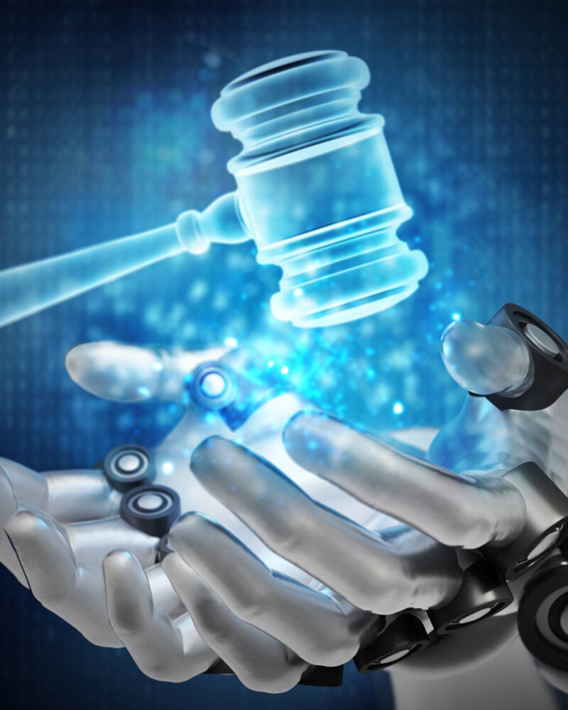 Blue gavel hologram over robotic hands.