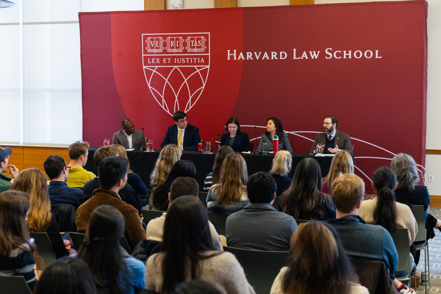 Five people sitting together, speaking on a panel