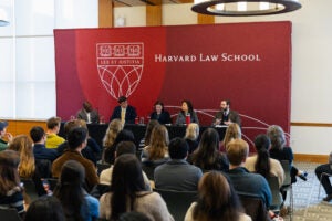 Five people sitting together, speaking on a panel