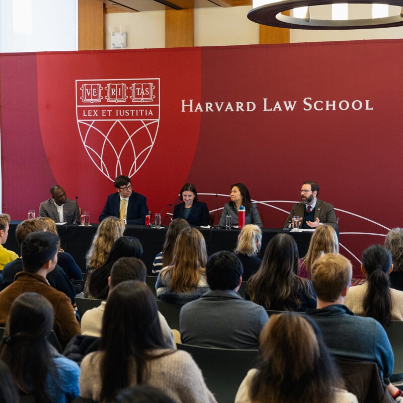 Five people sitting together, speaking on a panel